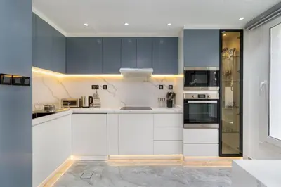 a kitchen with white cabinets and a stove top oven at White Sage Brand New 3BR Villa with Garden and Two Balconies in Dubai