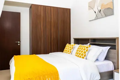 a bedroom with a bed with white and orange pillows at Cozy 1BR Apartment with Water View Business Bay in Dubai