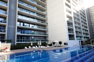 a swimming pool in front of a building at Cozy 1BR Apartment with Water View Business Bay in Dubai