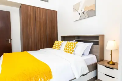 a bedroom with a bed with white and yellow pillows at Cozy 1BR Apartment with Water View Business Bay in Dubai
