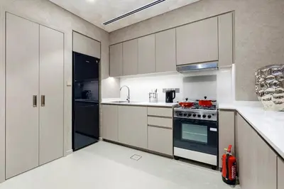 a kitchen with white cabinets and a stove at FIRST CLASS 1BR Stylish & Luxurious in Dubai