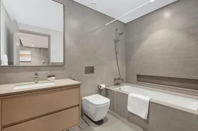 a bathroom with a tub and a toilet and a sink at FIRST CLASS 1BR Stylish & Luxurious in Dubai