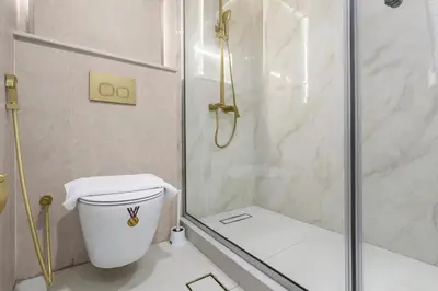 a bathroom with a shower and a toilet at Walk to Dubai Mall 2BR Apartment with Balcony and Pool in Dubai