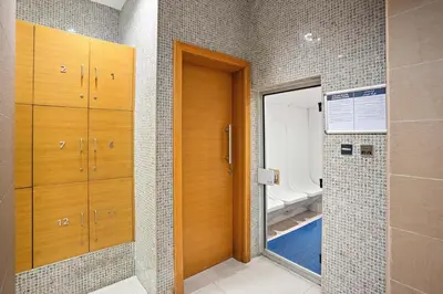 a bathroom with a walk in shower and a mirror at Walk to Dubai Mall 2BR Apartment with Balcony and Pool in Dubai