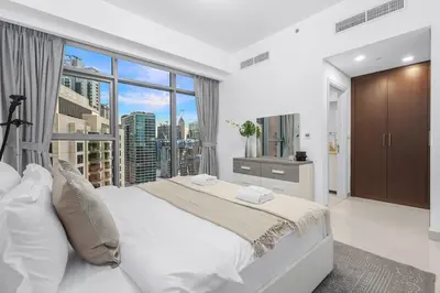 a bedroom with a large bed and a large window at FIRST CLASS 1BR Panoramic City View in Dubai
