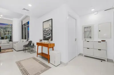a white living room with a desk and a couch at FIRST CLASS 1BR Panoramic City View in Dubai
