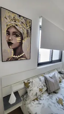 a bedroom with a painting of a woman on the wall at Modern 2BR -5MIN to Metro & Festival Mall- 1211 in Dubai