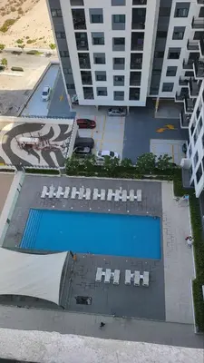 an overhead view of a pool with chairs and a building at Modern 2BR -5MIN to Metro & Festival Mall- 1211 in Dubai