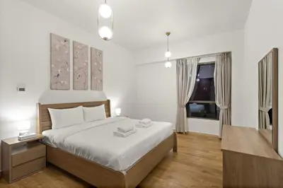 a bedroom with a large bed and a window at Luxe 2BR with Marina View in JBR and Walk to the Beach in Dubai