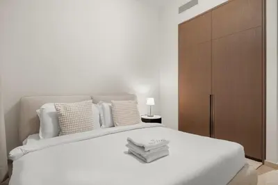 a white bedroom with a large white bed with pillows at FIRST CLASS 2BR Incredible Burj Khalifa View in Dubai