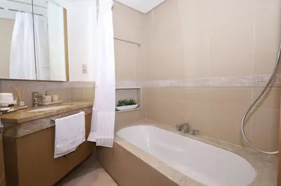 a bathroom with a bath tub and a sink at Lux 2 Bed in Downtown Dubai w Dubai Mall Access in Dubai