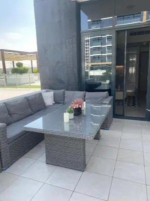 a couch and a table on a patio at furnished one bedroom huge terrace in Dubai