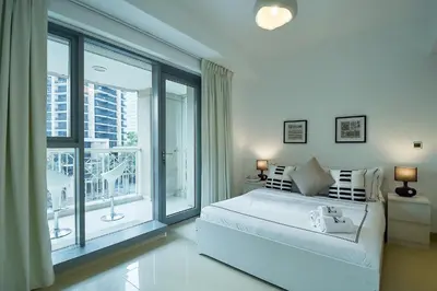 a white bedroom with a bed and a large window at Luxury Escapes - Modern 3BR Apt Stylish, Spacious and Comfortable in Dubai