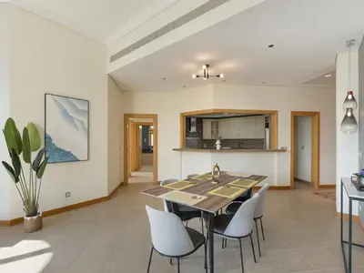 a dining room and kitchen with a table and chairs at Short-stay at Al Haseer - 4 Beds Palm Holiday Apt in Dubai