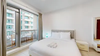 a bedroom with a white bed and a large window at BLVD Central 2 - Studio Apartment in Downtown in Dubai