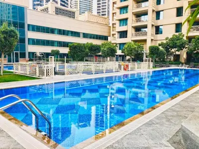 a large blue swimming pool in front of a building at BLVD Central 2 - Studio Apartment in Downtown in Dubai