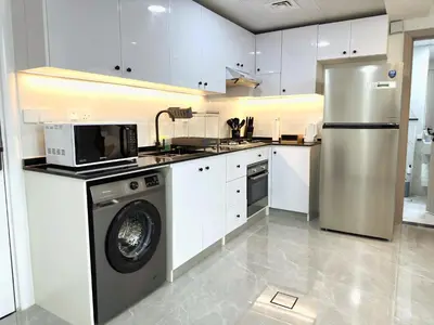 a kitchen with a washing machine and a refrigerator at Dubai Marina - 1BHK Fancy Apartment in Dubai