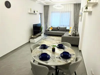 a dining table and chairs in a living room at Dubai Marina - 1BHK Fancy Apartment in Dubai