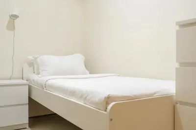 a bed with white sheets and a pillow on it at Lavish 3BR Apartment with Pool Access in Al Bateen in Dubai