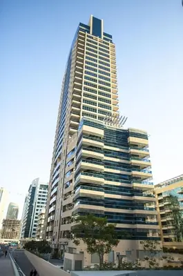 a tall building with a tree in front of it at One BedRoom near Beach and Metro in Dubai Marina Z1011 in Dubai