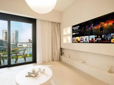 a living room with a large window and a tv at Act Tower Suites by Prestige Nest in Dubai