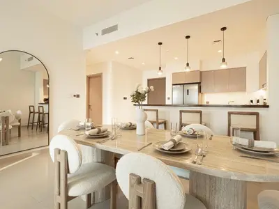 a kitchen and dining room with a large wooden table and chairs at Act Tower Suites by Prestige Nest in Dubai