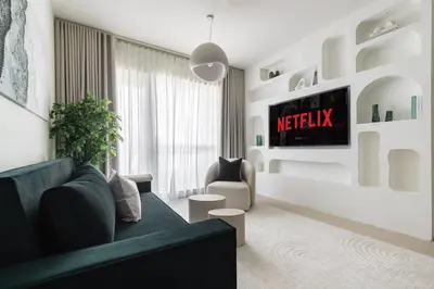 a living room with a couch and a tv at Kinfolk Homes - No 1 Family Stay, Partial Burj Khalifa Fountain View in Dubai