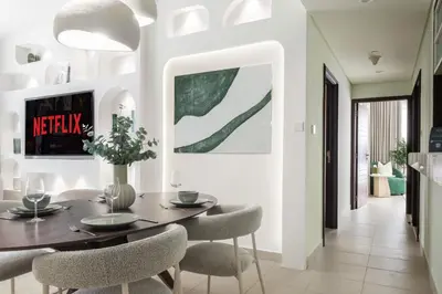 a dining room with a table and chairs at Kinfolk Homes - No 1 Family Stay, Partial Burj Khalifa Fountain View in Dubai