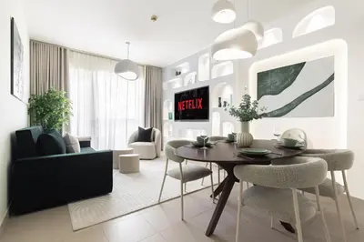 a living room with a dining room table and chairs at Kinfolk Homes - No 1 Family Stay, Partial Burj Khalifa Fountain View in Dubai