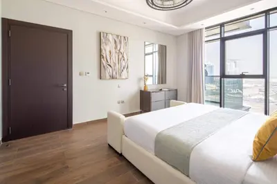 a bedroom with a large bed and a large window at Frank Porter - Nobles Tower in Dubai