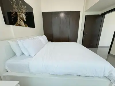 a white bed with white pillows in a bedroom at Lala Land Homes - Magnificent 1 Br in Business Bay in Dubai