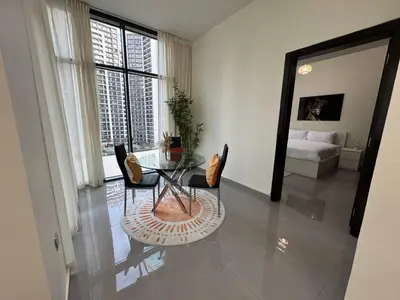 a living room with a glass table and chairs at Lala Land Homes - Magnificent 1 Br in Business Bay in Dubai