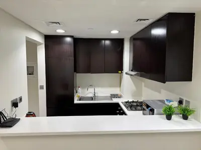 a kitchen with black cabinets and a white counter top at Lala Land Homes - Magnificent 1 Br in Business Bay in Dubai