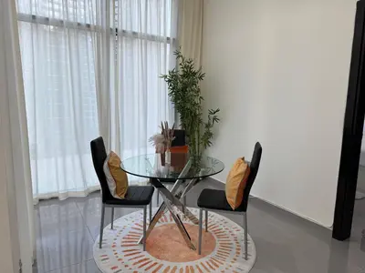 a glass table with chairs and a potted plant at Lala Land Homes - Magnificent 1 Br in Business Bay in Dubai