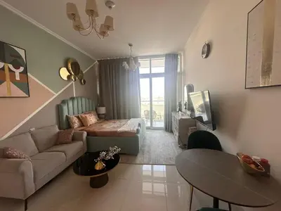 a living room with a bed and a couch and a table at Damac Hills in Dubai