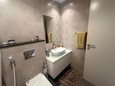 a bathroom with a sink and a toilet and a mirror at Damac Hills in Dubai