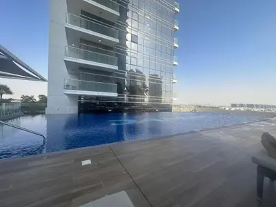a large building with a swimming pool in front of it at Damac Hills in Dubai