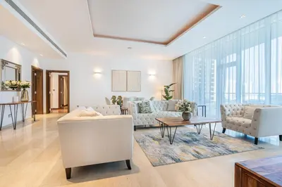a living room with white furniture and large windows at Palm Home next to Nakheel Mall with Private Beach in Dubai