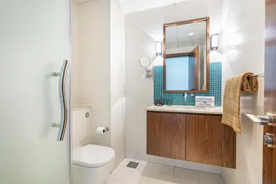 a bathroom with a toilet and a sink and a mirror at Palm Home next to Nakheel Mall with Private Beach in Dubai