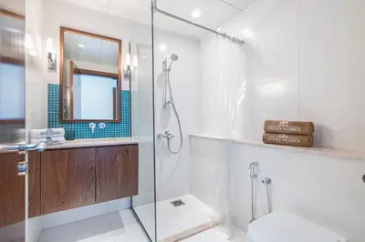a bathroom with a glass shower and a toilet at Palm Home next to Nakheel Mall with Private Beach in Dubai