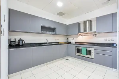 a kitchen with white cabinets and a sink at Palm Home next to Nakheel Mall with Private Beach in Dubai