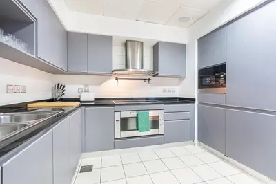 a kitchen with white cabinets and stainless steel appliances at Palm Home next to Nakheel Mall with Private Beach in Dubai