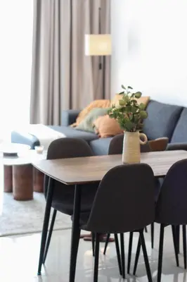 a living room with a table with chairs and a couch at Cozy 1 Bedroom Apartment in Dubai