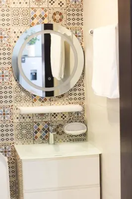 a bathroom with a mirror and a sink at Cozy 1 Bedroom Apartment in Dubai