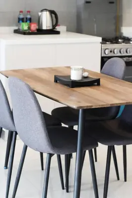a wooden table with four chairs around it at Cozy 1 Bedroom Apartment in Dubai