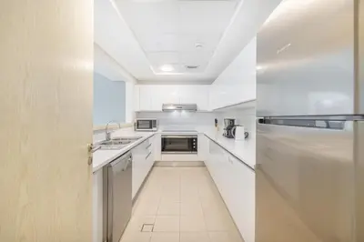 a white kitchen with a sink and a refrigerator at Premium 3-bedroom with Direct Beach Access in JBR in Dubai