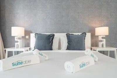 a white bed with two lamps and pillows on it at Premium 3-bedroom with Direct Beach Access in JBR in Dubai