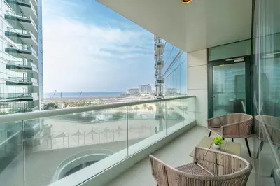 a balcony with chairs and a view of the ocean at Premium 3-bedroom with Direct Beach Access in JBR in Dubai