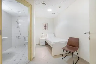 a bedroom with a bed and a shower and a chair at Premium 3-bedroom with Direct Beach Access in JBR in Dubai
