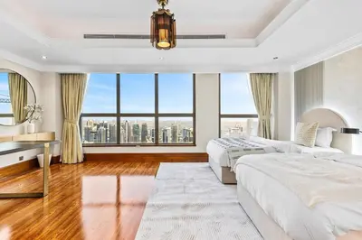 a bedroom with two beds and a large window at Luxury 6BR JBR Penthouse Panoramic Sea Views, Steps to Marina Beach & The Walk in Dubai